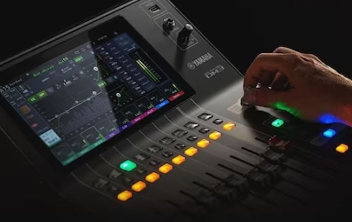 Zoso Music Yamaha DM3S 22-channel digital mixer with 9-inch touchscreen and motorized faders being operated by hand